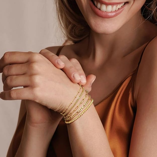 Elegante pila de pulseras de oro